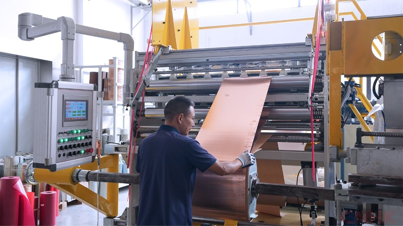 Operator feeding copper strip on the processing line