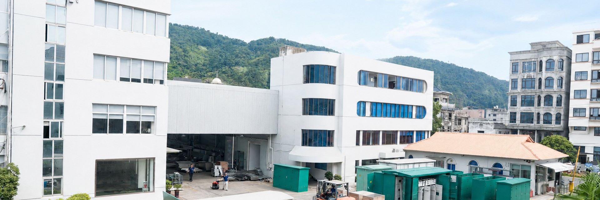 Huanghua factory buildings beside a green hillside
